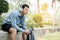 Man runner is sitting and holding bottle of water with headphones. Tired man is drinking water after run exercise