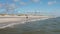 Man running along coast. Barefoot sportsman on sandy beach on sunny day. Waves rolling to coast. Denmark