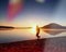 Man running on beach against backdrop of a beautiful sunset. Sand of mountain lake