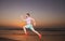 Man running on the beach at sunset. Athletic young man running in the nature.