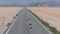 Man running down the endless road in the desert. Aerial view of the infinity.