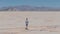 Man running down the endless road in the desert. Aerial view of the infinity.