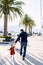 Man is running hand in hand with his toddler on a boat pier in Montenegro