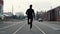 Man running in the middle of the street. Background shot. Slow motion. Abstract concept of individual success and fame.
