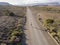 Man running on an open empty road in arid landscape