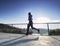 Man is running quickly on the shore bridge. Silhouette of active man