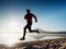 Man running at seaside twilight time. Runner athlete running at seaside. Sportsman fitness silhouette