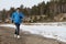 The man running on snow on the river bank