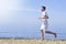 Man running on sunny beach. Unrecognizable body jogging on ocean beach. Running on tropical beach. Attractive man enjoying nature.