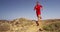 Man running on trail in desert - male athlete running fast outside