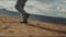 Man runs along tranquil river beach against white clouds