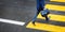 Man rushing over a road crossing in a city on a rainy day