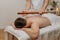 Man`s back during traditional thai massage with stick. Oriental alternative medicine with wooden tools. Body care and SPA in