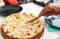 Man`s cutting pizza on a plate with a knife. Still life, dinner in the cafe, pizzeria.