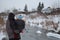 A man`s father stands with his back holding a small child in his arms looking at the river in winter