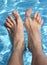 Man\'s feet on the bathtub of a relaxing pool