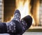 Man`s Feet in gray socks, before fireplace, in country house.