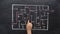 The man`s finger moves along the arrow indicating the exit from the maze. Drawing of a maze on a chalk Board