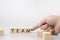 The man`s finger pointed at wood cube blocks write the word team on cement top table white background for business concept copy sp