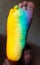 Man`s foot in the color of the rainbow