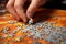 A man\\\'s hand assembles a puzzle on a table.