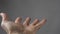 Man`s Hand Begs For Something On A Gray Background. Open Man`s Cupped Hand Begging For Alms On Gray Background. High Quality Pho