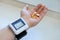 A man`s hand with a blood pressure monitor on his wrist and a medicine in the palm of his hand. Selective focus