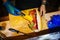 Man\'s hand with blue gloves assembling a sandwich on a wooden cutting board