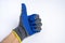 a man& x27;s hand in blue rubberized work gloves shows a thumbs up on a blue background