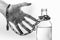 Man`s hand in a chain with lock reaches for a bottle of alcohol. concept of alcohol dependence