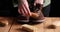 Man`s hand clean suede shoes, boots with a brush on wooden background.