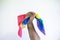 A man`s hand with a clenched fist holding a flag of the LGBT community. Concept of fight for equality