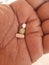 man\'s hand contains three medicinal tablets, white, green and yellow, in preparation for treatment