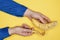 Man`s hand in a corduroy shirt holds a banana on the peel of which is written