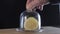 A man`s hand covers glass lid on a dish with a lemon cut in half