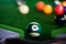 Man\\\'s hand and Cue arm playing snooker game or preparing aiming to shoot pool balls on a green billiard table. Colorful snooker