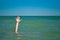 A man`s hand drowns in water calling for help, against the background of the sea and sky clouds summer