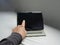 man\'s hand firmly grasps the sleek tablet, its modern design perfectly fitting within his grasp. With a determined look