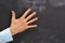 Man\'s hand gesturing on dark chalkboard with copy-space