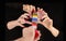 Man\'s hand giving a colorful pipe and four woman hands taking it