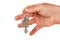 Man`s hand giving a new metal key with home shaped keychain, isolated. New home concept