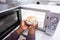 Man`s Hand Heating Food In Microwave Oven