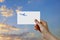Man\'s hand holding airplane symbol paper in sky. Concept of journey, travel, dream, freedom. Hand is holding paper airplane