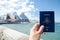 A man`s hand holding Australia passport with blurred background of Sydney Opera House for Concepts of traveling.