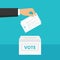 Man\'s hand holding ballot paper and putting it into ballot box. Elections and voting