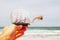 Man\'s hand holding decorative boat in the bottle in front of sea horizon. vintage filtered.