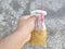 a man& x27;s hand is holding a drink in a plastic bag with a red pipette, the drink in Indonesian is called es cendol dawet