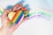 Man`s hand holding a heart with lgbt symbols. Drawn rainbow in the background. Free love. Lesbian Gay Bisexual Transgender.