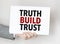 man\'s hand holding paper sheet with truth build trust words