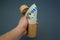 Man`s hand holding recycled paper tube with euro money. Recycling packaging and saving money concept